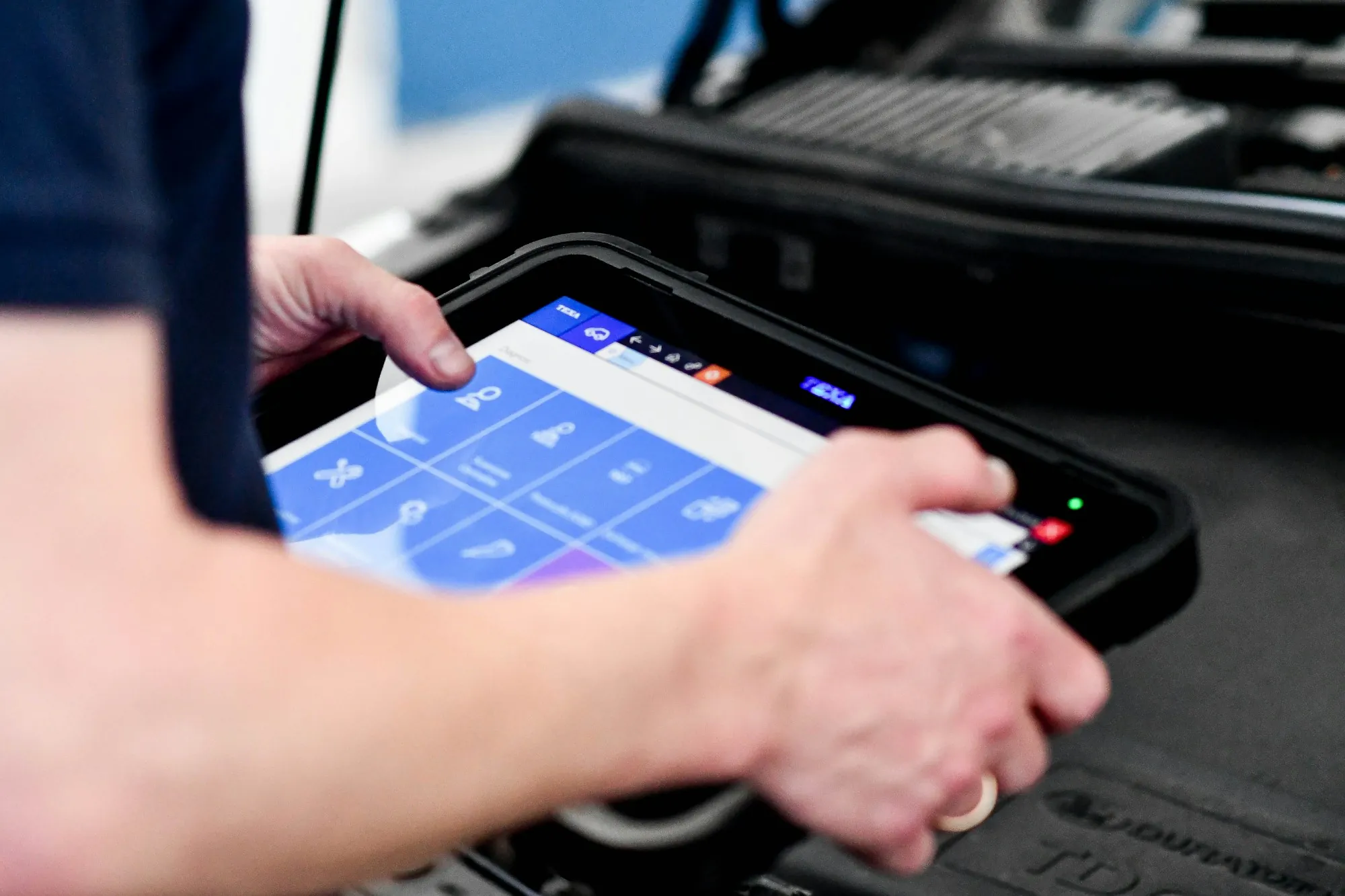 Hand using a handheld diagnostic scan tool