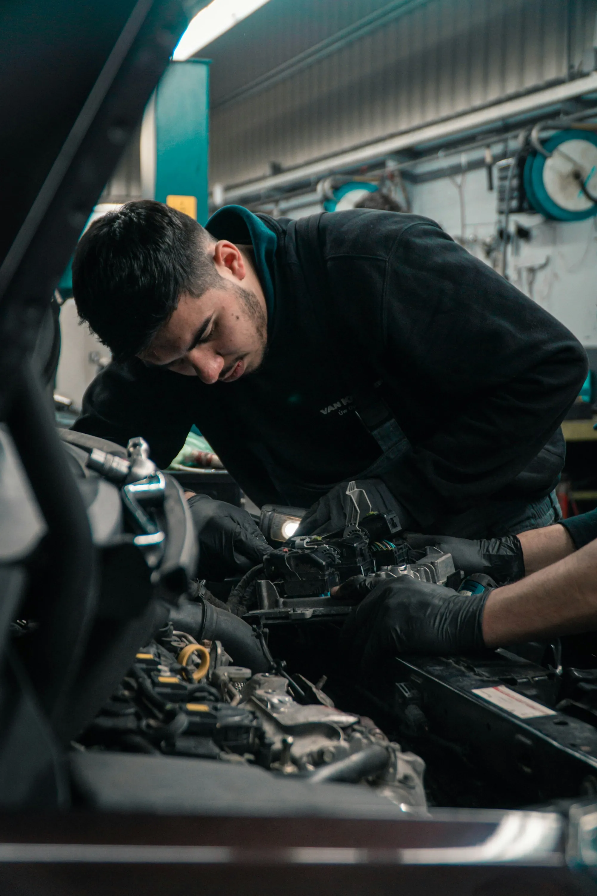 Mechanic leaning into an open engine bay