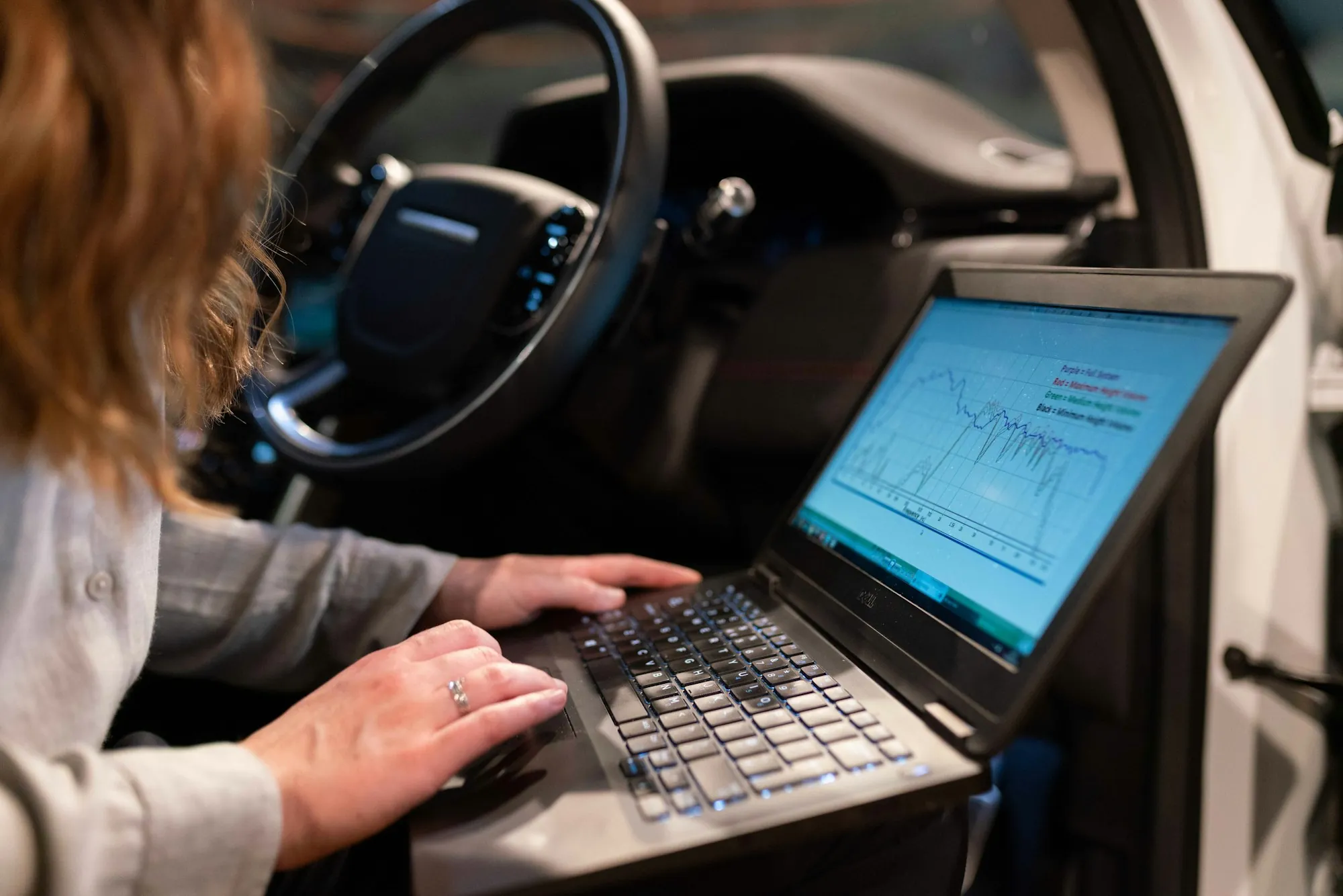 Laptop showing fault data on the seat of a car